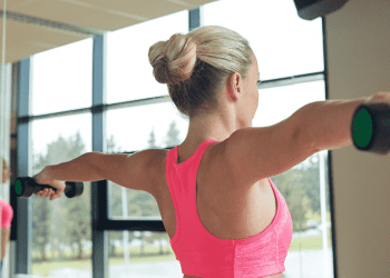 woman holding dumbbells straight out