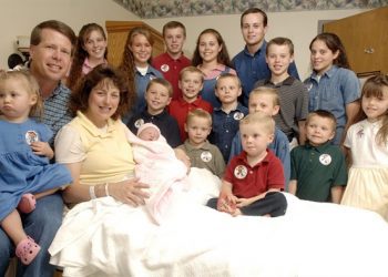 FILE — In this Aug. 2, 2007 file photo, Michelle Duggar, left, poses with her husband Jim Bob, second from left, and children, including their oldest son Josh, tallest standing, after the birth of her 17th child in Rogers, Ark.