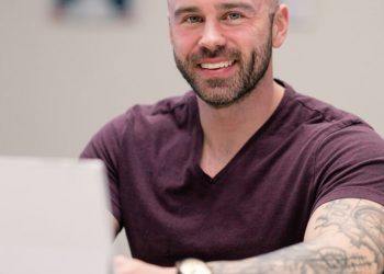 Photograph of nutrition coach Dan Garner sitting at a desk in front of a laptop computer.