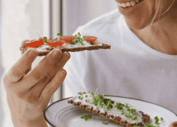 woman smile as she eats healthy snack