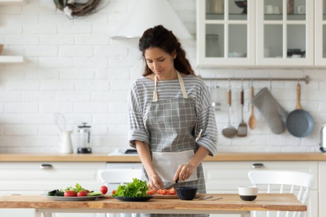 women chopping vegetables in kitchen