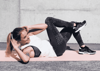 Woman lying on back in living room doing ab exercises