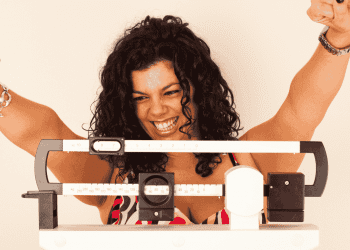 woman celebrating on the scale for weight loss