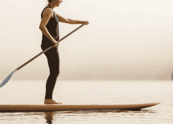 woman paddleboarding on foggy morning
