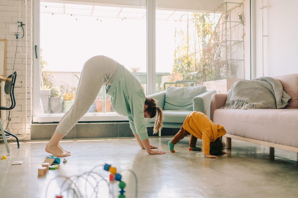 Mother and baby doing bear crawl together in brightly lit room