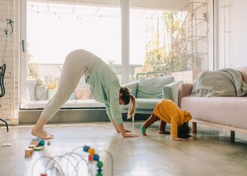 Mother and baby doing bear crawl together in brightly lit room