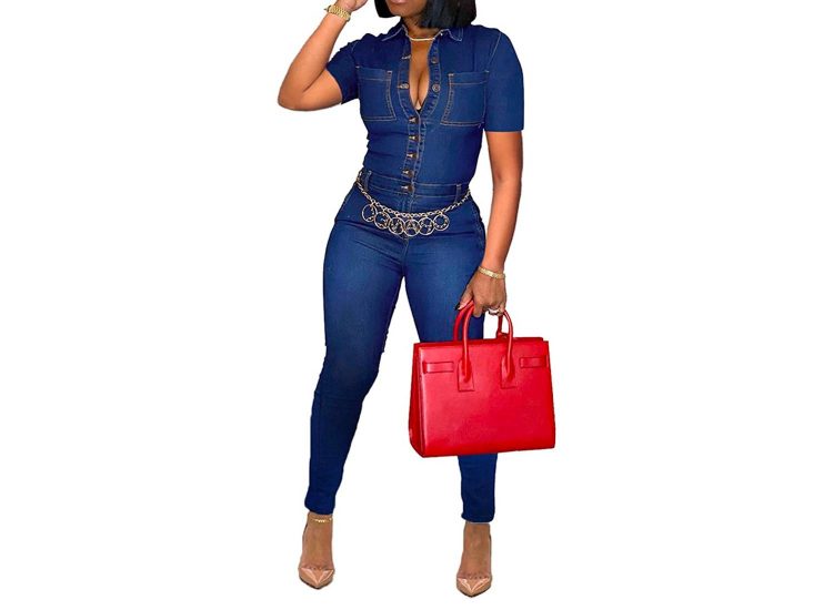 A woman wearing a dark blue denim jumpsuit with a chain belt and red purse