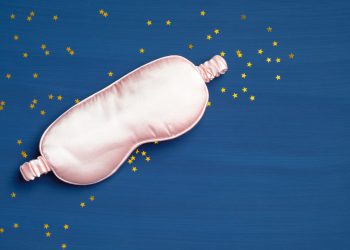 pink silk eye mask on navy blue background importance of sleep in fitness