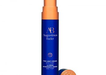 A navy blue metal tube of the Augustinus Bader The Light Cream on a white background