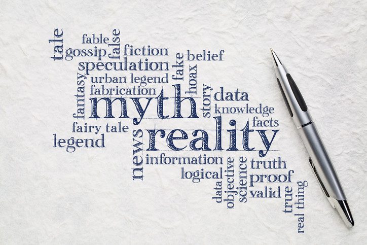 A word cloud illustrating "myth" and "reality" in blue words against white background with silver pen; contrasting phrases include "urban legend," "data, "fake," and "proof"