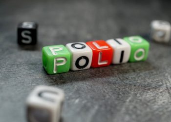 Dice of different colors spelling out "polio" on a dark background