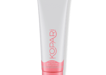 closed white and pink tube of Kopari Tropical Glow Cleanser on a white background