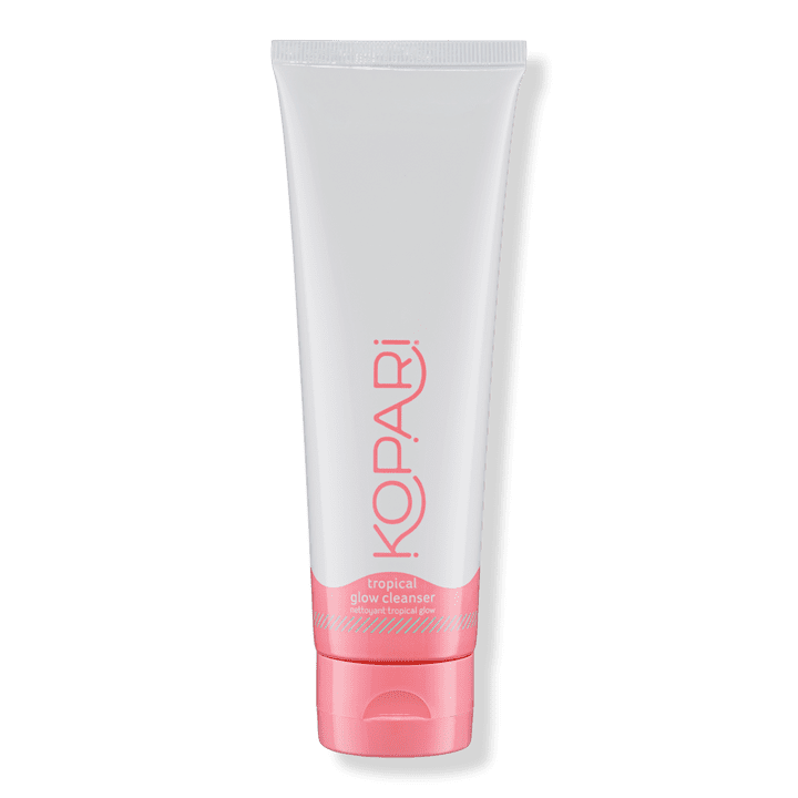 closed white and pink tube of Kopari Tropical Glow Cleanser on a white background
