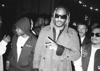 Image may contain Sunglasses Accessories Accessory Clothing Apparel Human Person Coat Overcoat Face and Skepta