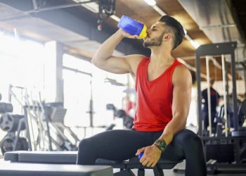 Man drinking protein drink at the gym