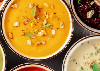 Bowls of various types of gluten-free soup including roasted pumpkin, tomato and creamy potato