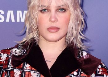 Image may contain Hair Blonde Person Adult Face Head Clothing and Coat