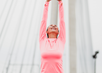 woman stretching to the sky on a bridge