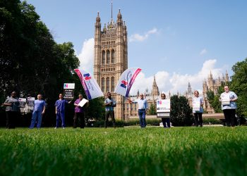 Nurses with placards outside the Royal College of Nursing in Victoria Tower Gardens, London, following the government's announcement of the NHS pay offer, on July 21, 2021. (Jonathan Brady—PA Wire/AP)